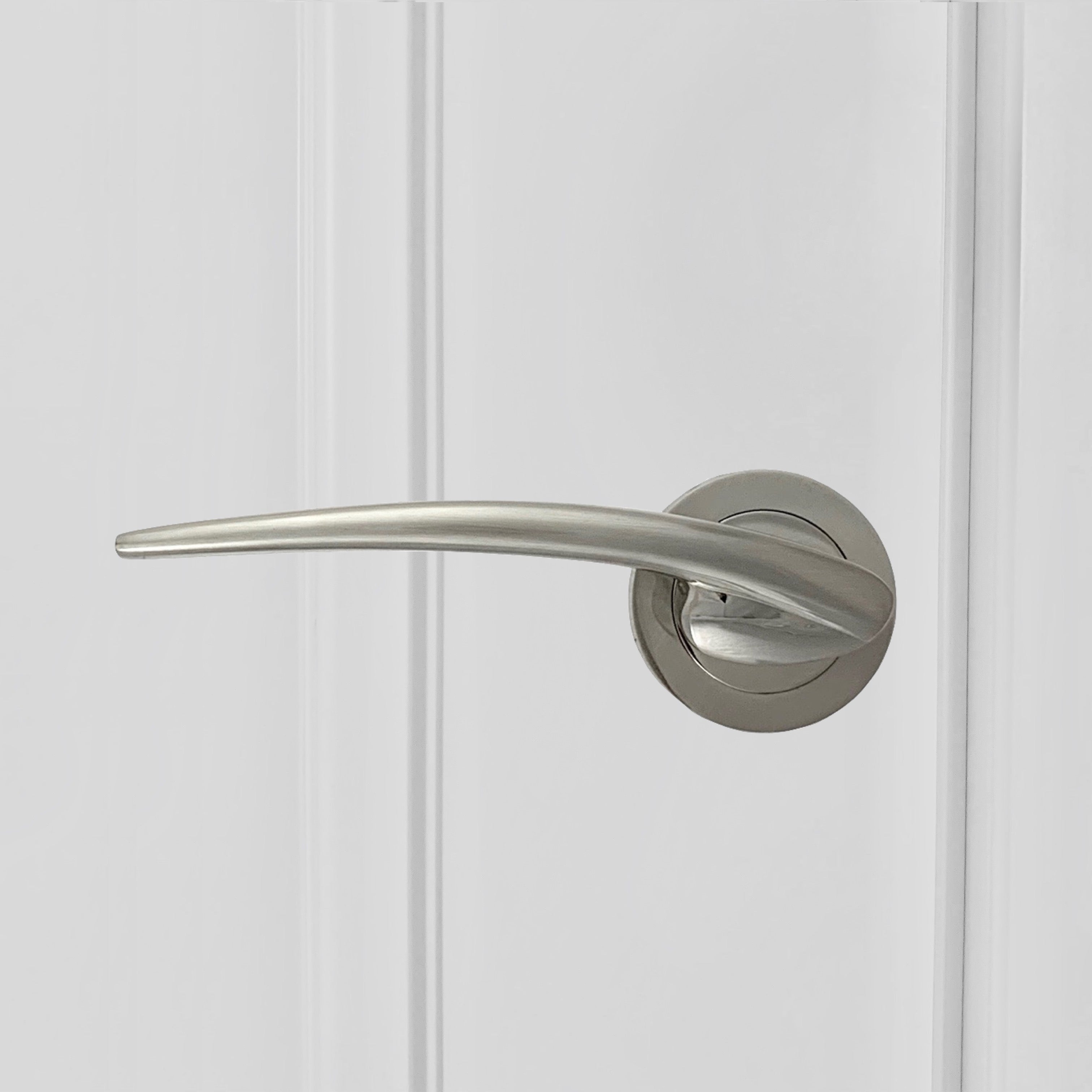 Manilla de zamak con roseta redonda en acabado níquel satinado para puertas de madera lacada blanca